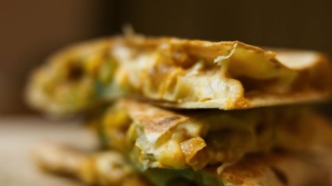 Freshly fried hot vegetable quesadilla on a wooden cutting board. Process of making mexican quesadillas. Macro view, slowmotion