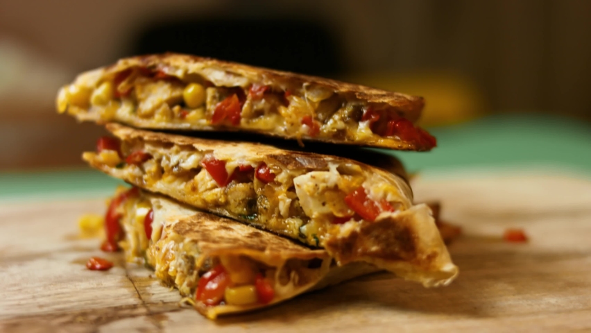 Side view of freshly fried hot chicken quesadilla on a wooden cutting board. Process of making mexican quesadillas Royalty-Free Stock Footage #1070089975