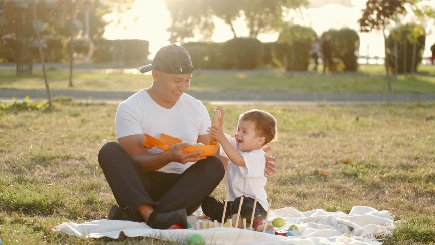 Fathr and little son with lunchbox outdoors