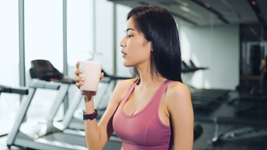 Attractive fitness asian woman finishing workout and drinking protein milk shake vitamins after training. Bodybuilding. Healthy lifestyle. Royalty-Free Stock Footage #1070097049