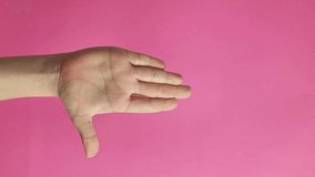vertical video. violence gesture of women, baby hand. Isolated on pink background.