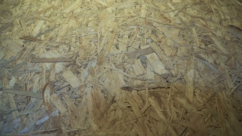 OSB board stored in a warehouse. Sheet building material for the construction of partitions. Wooden OSB board for building a house.