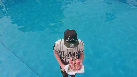 Kryvyi Rih, Ukraine - 03.04.2021 a guy with a bouquet of flowers falls into the pool, slowly, 4k
