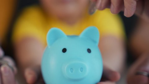 Family piggy bank for investment. Happy family throws coins into piggy bank. Financial business. Hands throw coins into piggy bank. Family business. People are counting coins. Girl with piggy bank