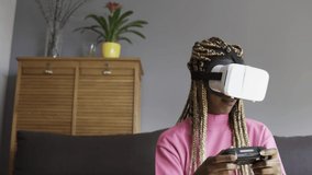 African girl with playing console games wearing virtual reality goggles at home - Vr, fun trend technology concept