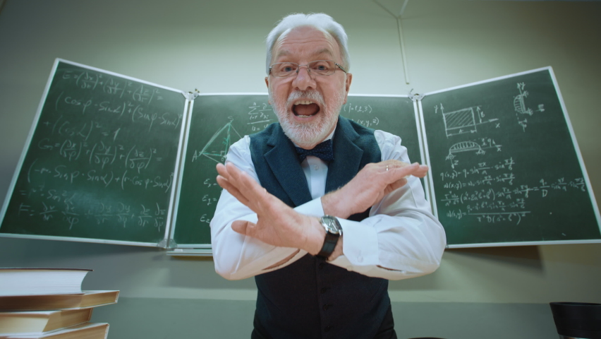 Emotional crazy teacher trying explain mathematical formulas written in chalk on blackboard in classroom. POV view funny senior professor emotionally speaking to student who does not understand math Royalty-Free Stock Footage #1070128165