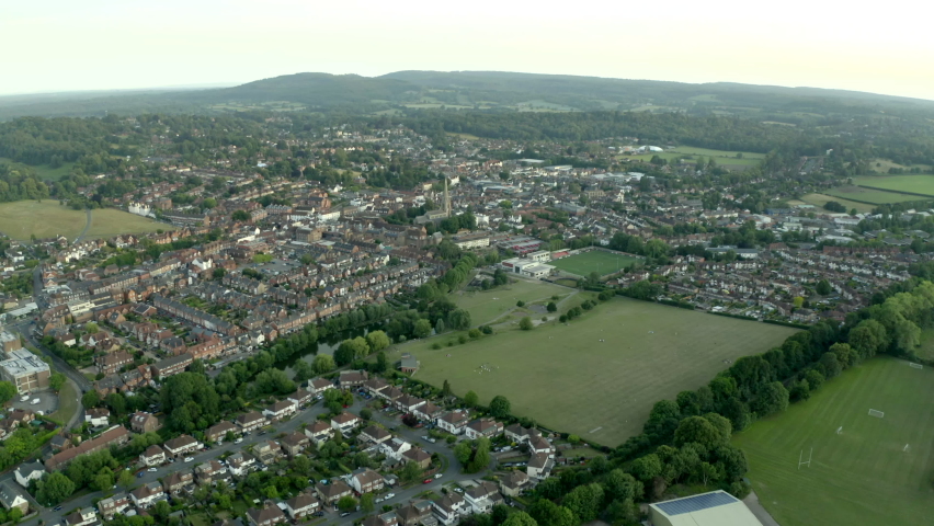 Cinematic drone aerial footage of beautifu classicl English Town in countryside, with old church in frame