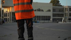 Security Officer Holding Two-way Radio And Wearing Bright High-visibility Vest Standing In The Street. - medium shot - Powered by Shutterstock - Get 15% off with code: PIKWIZARD15