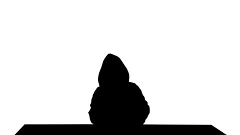 Silhouette Anonymous kid in a Fawkes mask using laptop.