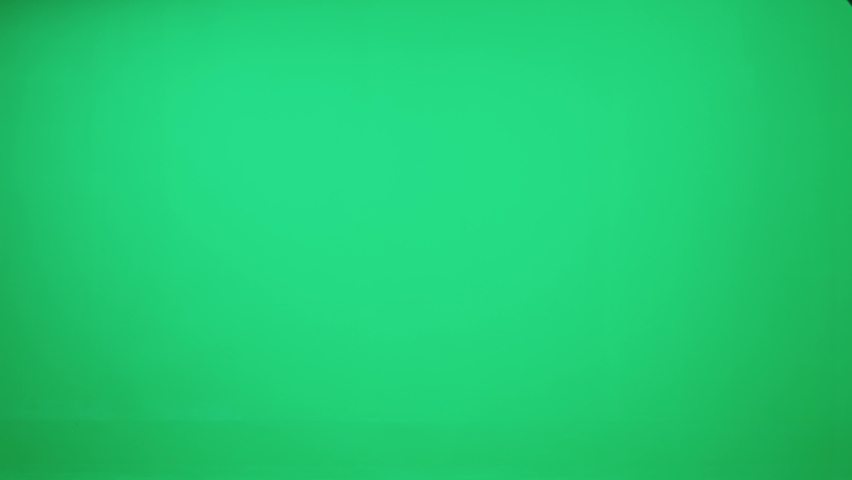 Cheerful man courier in uniform walks with a cardboard box in his hands on a green background, delivery service, chromakey template. | Shutterstock HD Video #1070144542
