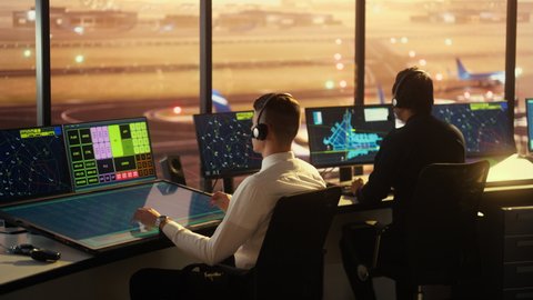 Diverse Air Traffic Control Team Working in a Modern Airport Tower at Sunset. Office Room is Full of Desktop Computer Displays with Navigation Screens, Airplane Flight Radar Data for Controllers.