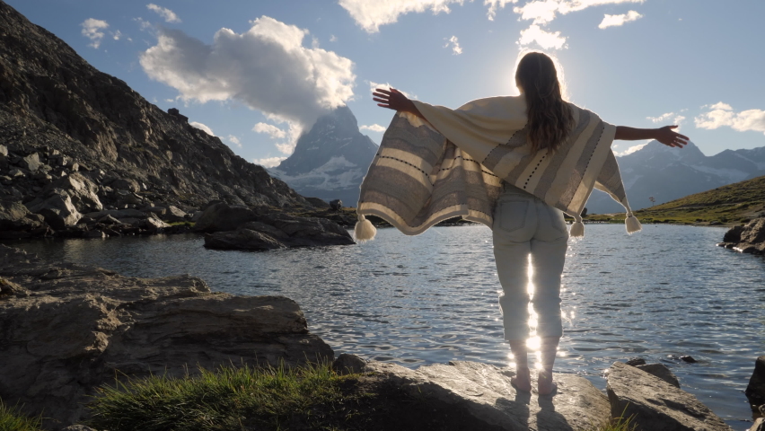 Slow motion: Woman stands baby mountain lake enjoying alpine landscape in Switzerland 