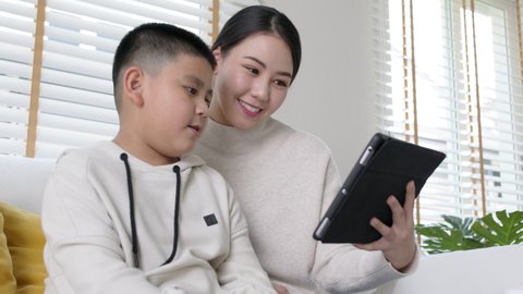 Young asia parents and son talk to doctor on cellphone videocall conference medical app in pediatric care online telehealth telemedicine online service hospital quarantine social distance at home.