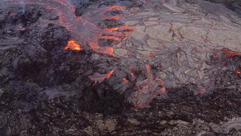 Aerial view of a field with a molten magma river and volcanic rock - high angle, drone shot