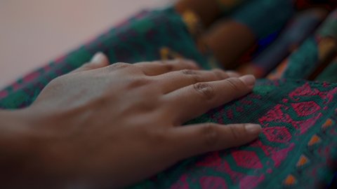 Mayan woman hand touching a colorful handmade Guatemalan Textile