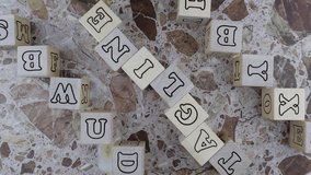Tagline concept with the word on wood blocks and upper and lower borders of wooden cubes with random letters over a marbled stone background. Rotating table - Powered by Shutterstock - Get 15% off with code: PIKWIZARD15