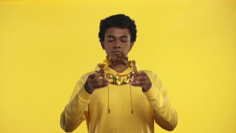 african american teenager wearing crown isolated on yellow