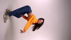 Vertical shoot of smiling woman dancing on grey background - Powered by Shutterstock - Get 15% off with code: PIKWIZARD15