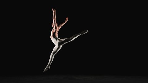 Male ballet dancer performs acrobatic element on a black background. Slow motion
