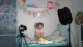 Adorable 6-year Old Little Girl Blogger Recording Crafting Tutorial Video at Home. Using Camera on Tripod and Professional Lighting Equipment. Social Media Influence People, Streaming Online Podcast