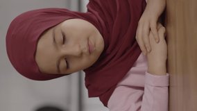 A cheese bread comes before the Muslim little girl wearing a headscarf to eat.The little girl does not like it, she turns her head. Dislike food concept.Video for the vertical story.
