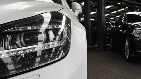 Close up details of headlights of anonymous prestigious white luxury modern car. Headlight. Close up shot.