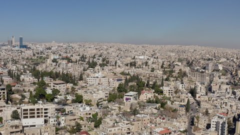 Drone video of the historic center and downtown with skyscrapers. Houses on the mountains in a landscape with streets and windows, city life. Aerial view Amman Jordan.