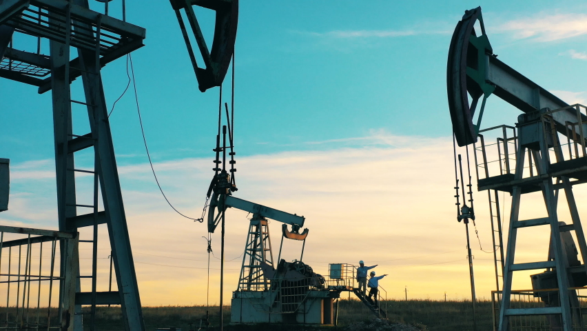 Multiple working oil pumps in an oil field at bright sunset Royalty-Free Stock Footage #1070188954