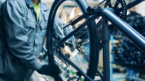 A bike is getting fabricated and adjusted by a worker
