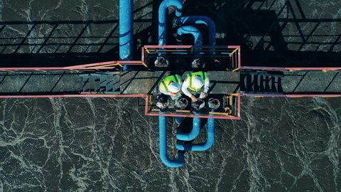 Top view of two workers standing on the sewage cleaning construction
