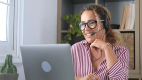 Attractive caucasian woman sit at homeoffice room wearing headset take part in educational webinar using laptop. Video call event with clients or personal chat with friend remotely concept
