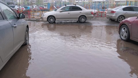 04.04.2021, Russia, Chelyabinsk: huge puddle among the cars.  Problems of public utilities and roads.