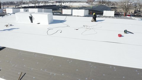 Aerial view of an industrial roof. Roofers installing a new roof on an industrial building.