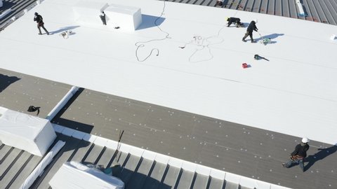 Aerial view of an industrial roof. Roofers installing a new roof on an industrial building.