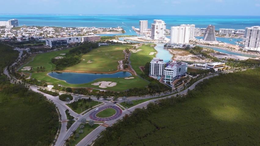 Aerial view of a luxury residential complex showing condominiums, golf course, yacht club and shopping center.