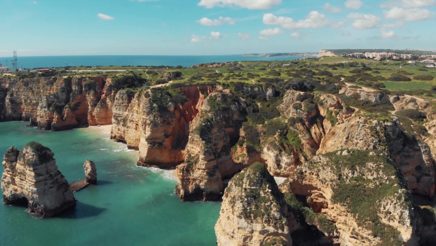 Algarve rocky eroded cliffs. Atlantic coast off Lagos, Portugal. Orbiting shot