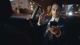 Handsome man recording message on phone in car. Calm male professional telling work news on video on smartphone in car. Elegant business man talking on video chat in business car.