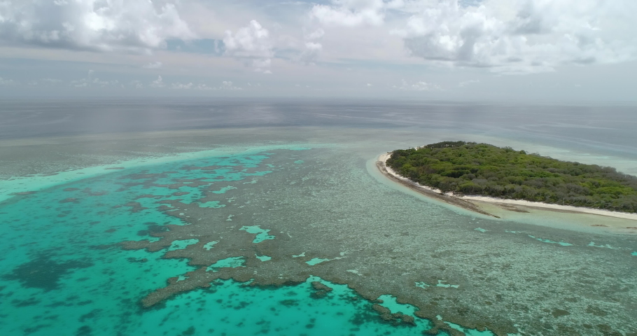 Left to right circular tracking aerial view over the blue water and corals of the great Barrier Reef with the coral atoll called Lady Musgrave island, Queensland, Australia