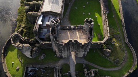 Welsh flag waving on gatehouse of Caerphilly Castle, United Kingdom, aerial view.