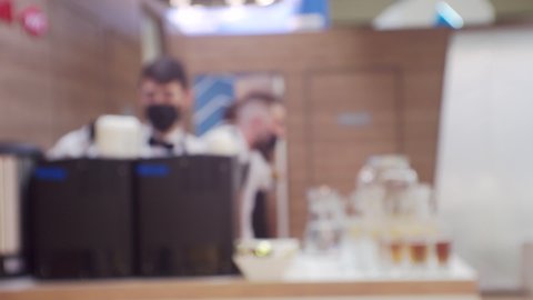 Modern small business.Silhouettes of several unrecognizable waiters in the same uniform working in a cafe.Blurred defocused video.Screensaver or background on a business theme