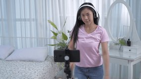 Holiday concept of 4k Resolution. Asian girls listening to music and dancing happily at home.