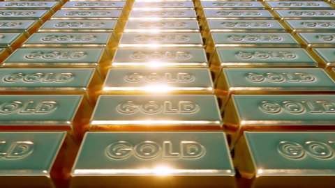 A close-up view of solid gold bars and ingots shining in the light.