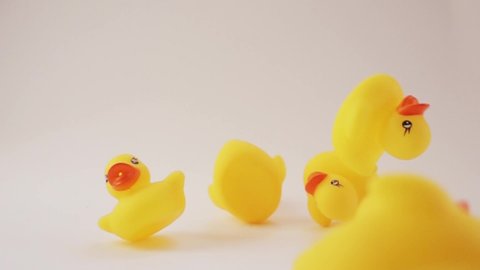rubber ducks. rubber ducks fly on a white background. Slow motion. Slow-motion shooting of objects. Yellow ducks video.