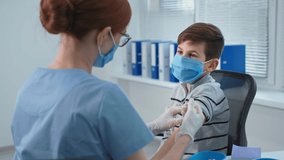 children health, woman doctor in mask and glasses gives an injection to a boy patient in a hospital - Powered by Shutterstock - Get 15% off with code: PIKWIZARD15