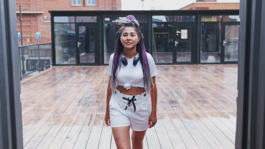 Confident Successful Mixed-race Young Woman Going Fast and Looking in Camera. White Wear, Colourful Violet Dreadlocks. Adult Cool Girl Walking in a hurry Outdoor. Modern Hipster People of gen z Royalty-Free Stock Footage #1070235697