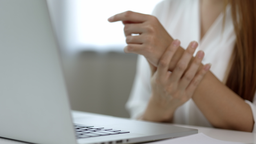 Close up hand woman texting on keyboard laptop work so hard and long time that he has office syndrome. She has wrist pain, from working with laptop sitting in office Royalty-Free Stock Footage #1070236711