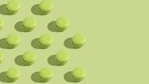 Green macaron pastries photographed on light green paper background appearing one by one creating a hard light pattern