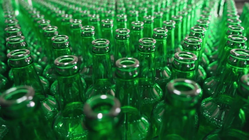 Technological line for bottling of beer in brewery. Empty brown bottles in a line in factory. Bottles Moving on Conveyor Belt at Glass Bottle Factory. Clean beer bottles are moving along the conveyor Royalty-Free Stock Footage #1070244973