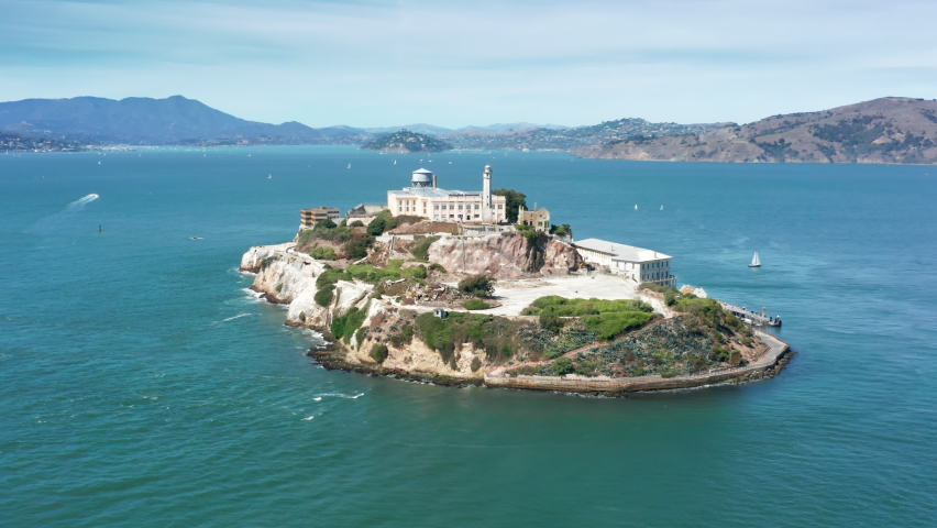 Close up Alcatraz island 4K aerial. Historic building surrounded by blue Pacific ocean waters. World famous landmark Alcatraz island national park. Prison building on island in San Francisco bay area Royalty-Free Stock Footage #1070253598