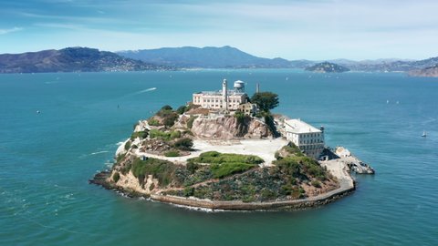 Close up Alcatraz island 4K aerial. Historic building surrounded by blue Pacific ocean waters. World famous landmark Alcatraz island national park. Prison building on island in San Francisco bay area